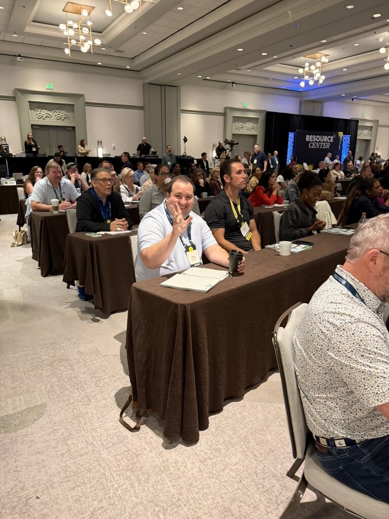 Law firm owners raising their hands in a large HTM conference room